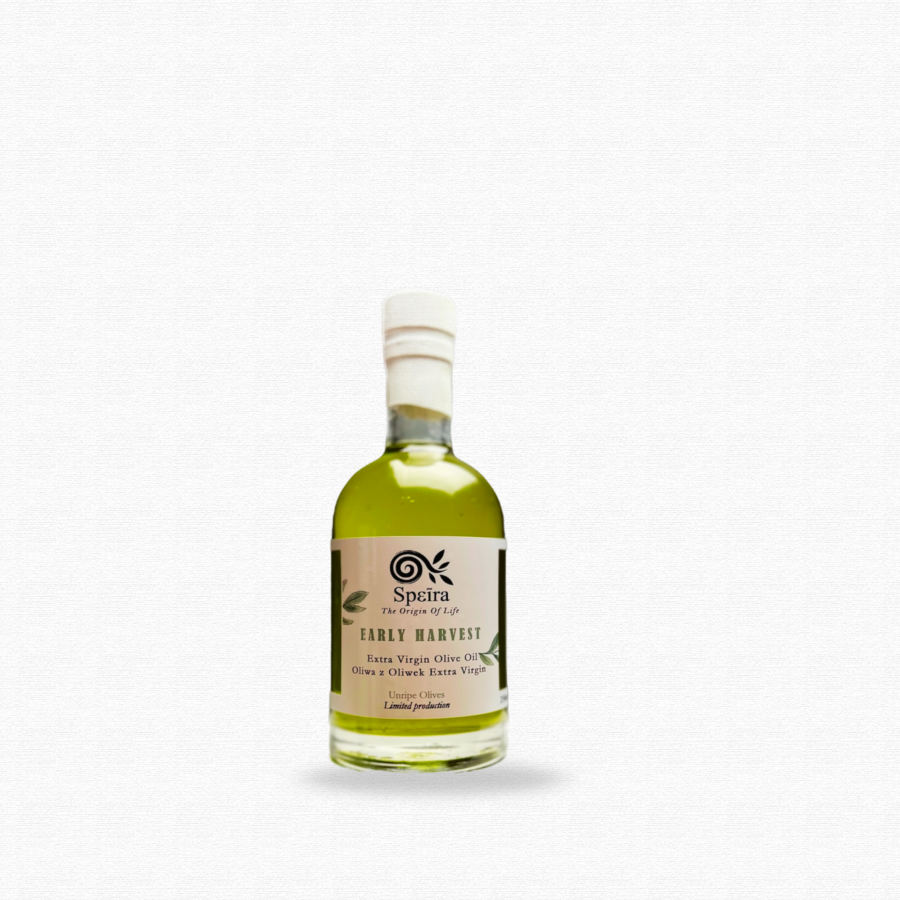 transparent glass bottle with green early harvest olive oil inside with white label and white font